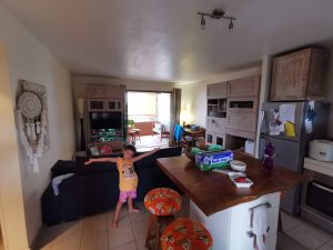 Young boy standing with arms opened in the middle of the living room