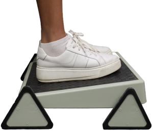 Two feet shown resting on a Footrest as an example of Assistive Technology