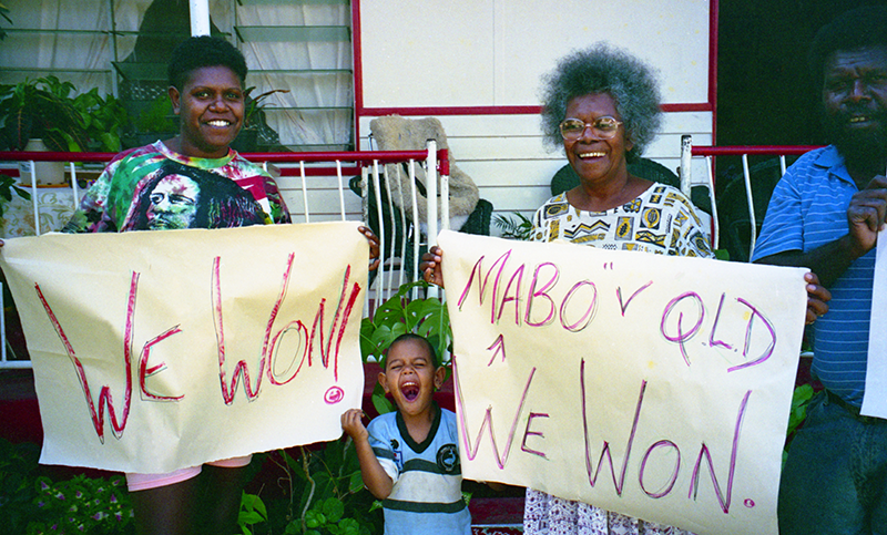 Bonita and some family members holding handmade posters"We won!"and "Mabo v Qld We Won"