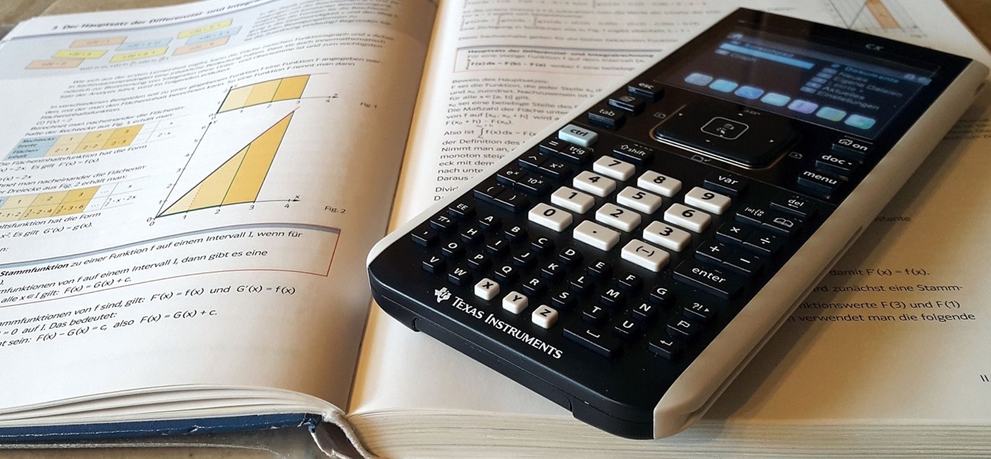 Calculator lying on open textbook