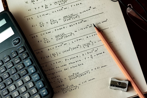 Calculator lying on page of maths equation