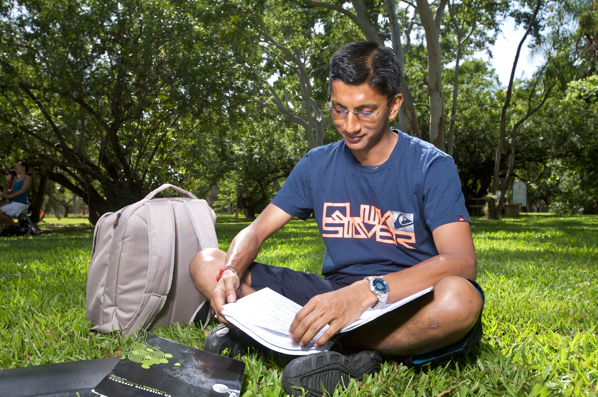 Male student sits reading a textbook
