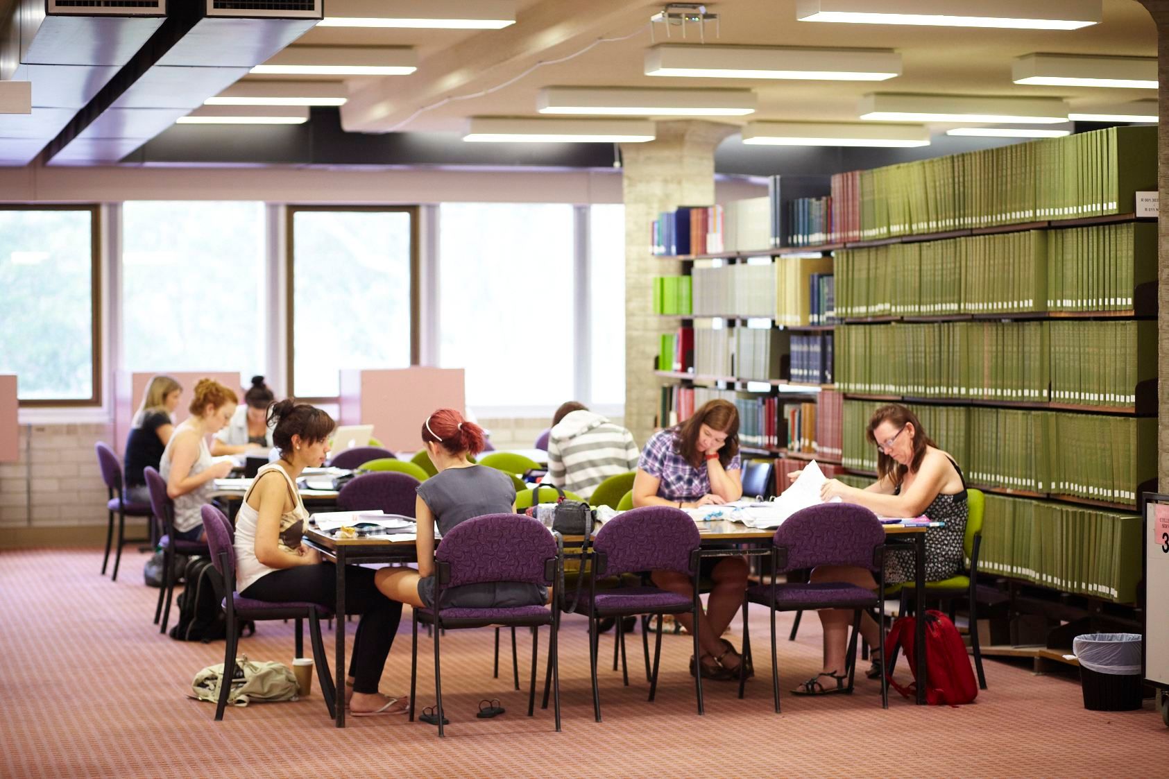 Students sit reading in the library