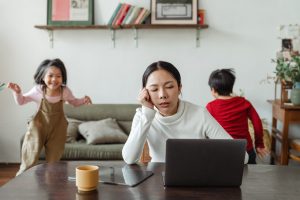 Mother trying to study with two children running around her