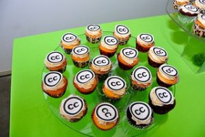 cupcakes with the CC logo as icing on a green table